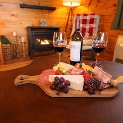 Wine and a cheese board set out by the fire at Oliver's Outlook